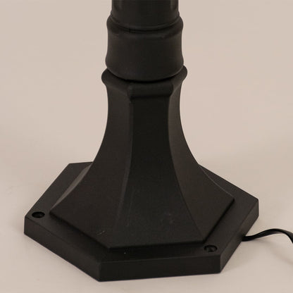 Detailed closeup of black outdoor post lamp showing textured metal body and ribbed glass for refined outdoor decor.