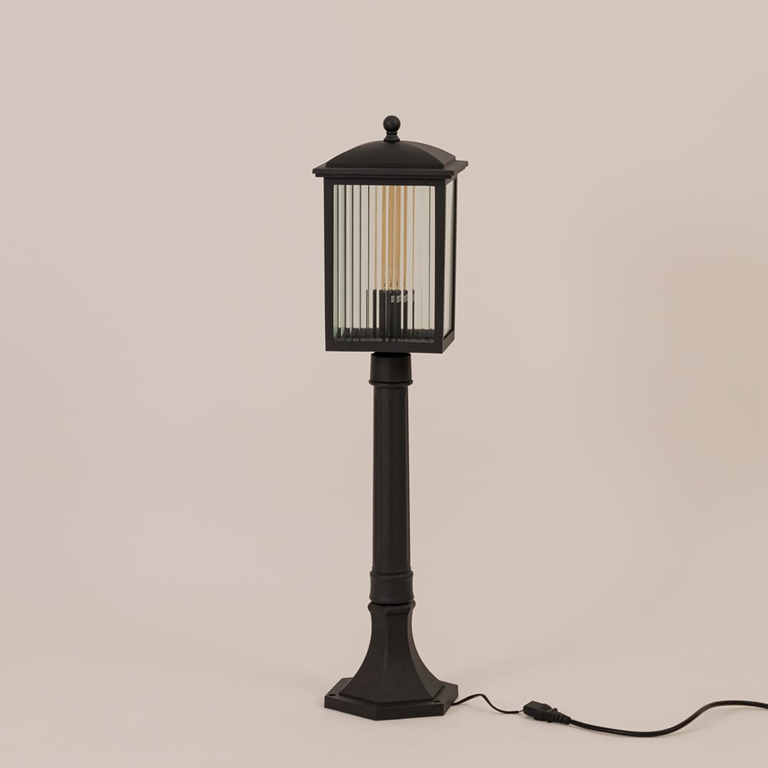 Black outdoor post light with ribbed glass shown switched off on white background perfect for outdoor entrances.
