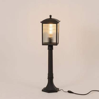 Black outdoor garden light with warm glowing ribbed panels for elegant exterior decor styling use.
