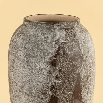 Decorative ceramic vase closeup highlighting natural stone texture speckled glaze and handcrafted finish with earthy tones on a soft neutral background.