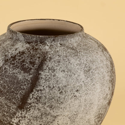 Detailed view of handcrafted ceramic vase with rustic grey brown texture and artistic round body design.