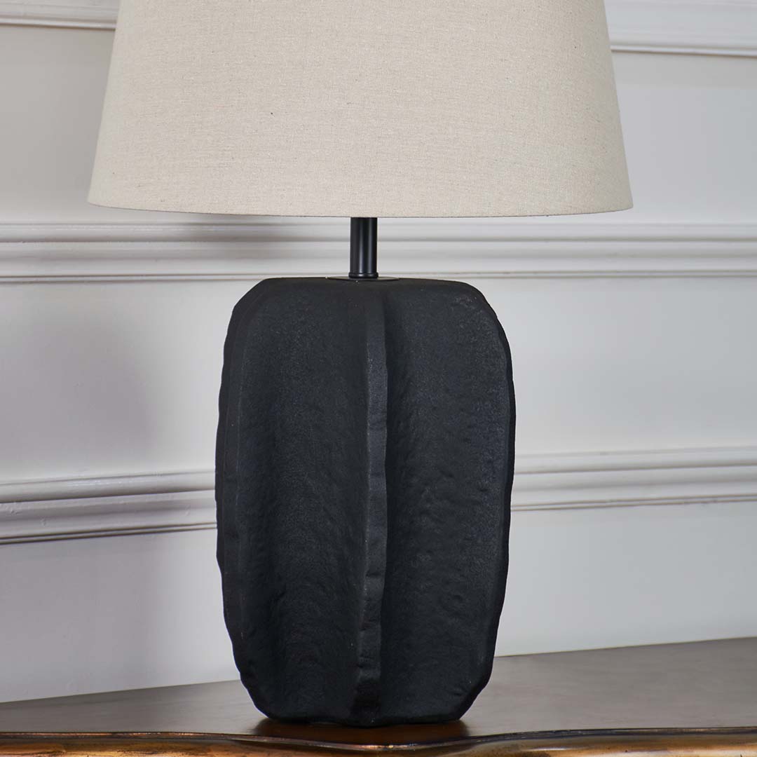 Black ceramic table lamp base highlighting handcrafted texture and contemporary design for stylish interior lighting.