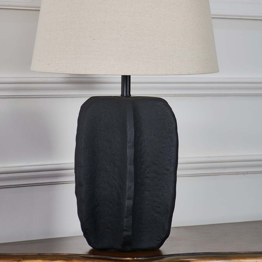 Black ceramic table lamp base highlighting handcrafted texture and contemporary design for stylish interior lighting.