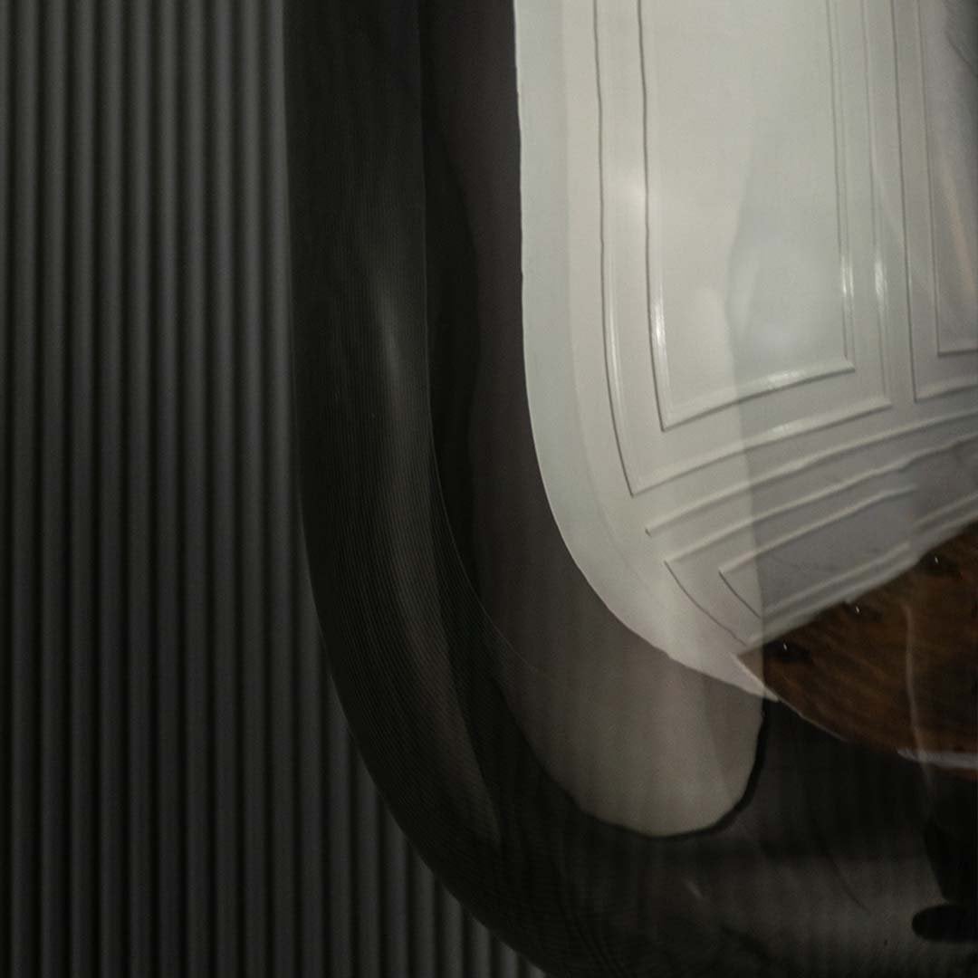 A detailed close view showing the smoked glass top section with its black metal support and modern rounded shape for stylish interior lighting.