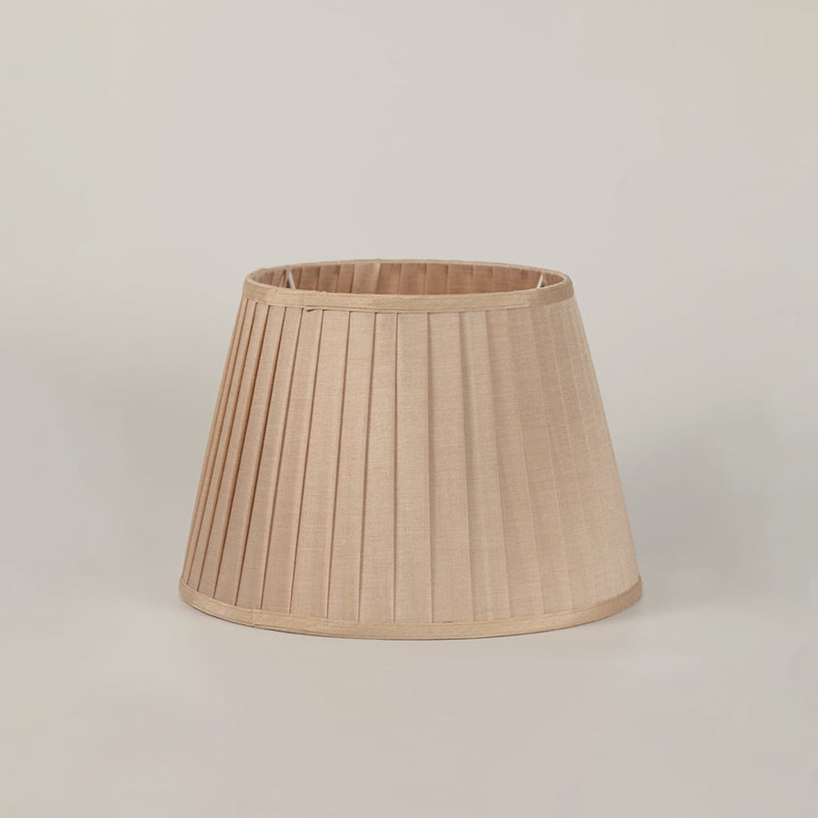 Green bird table lamp shade on white background with lights off showcasing artistic hand painted ceramic design and beige shade.