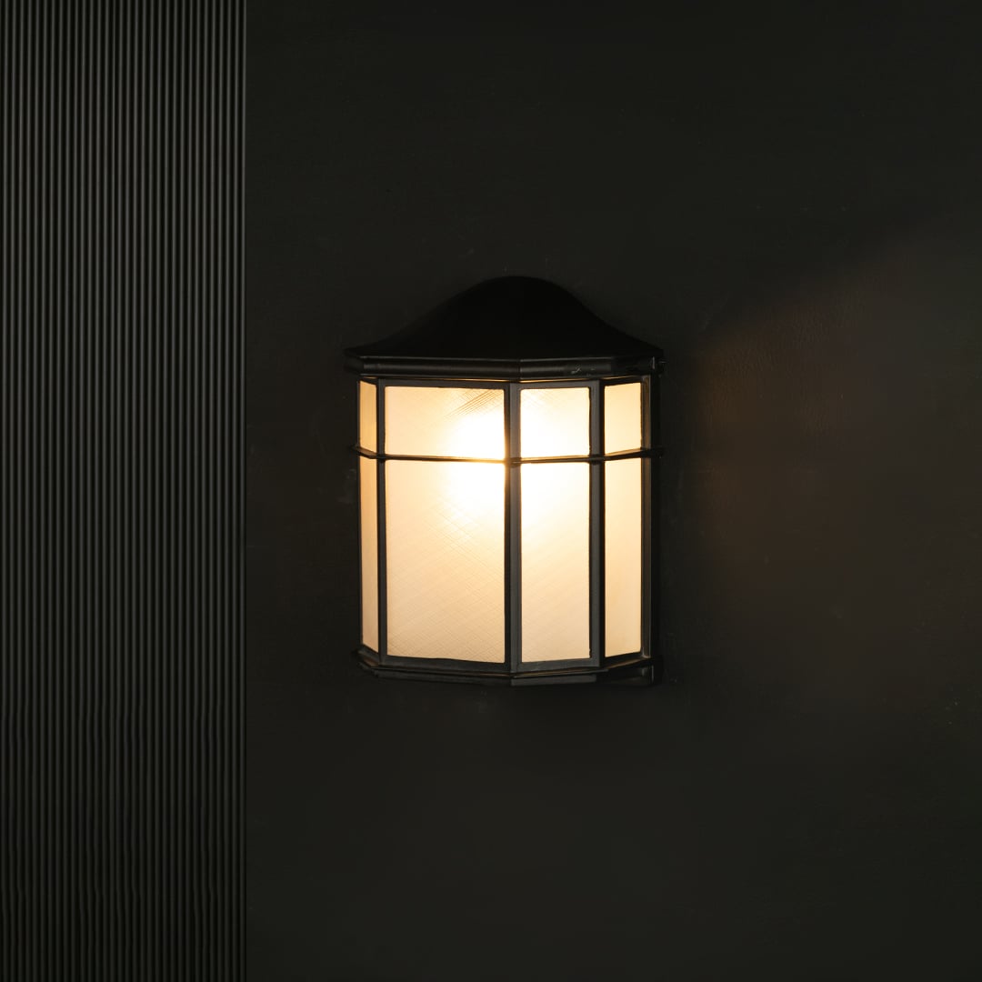 Outdoor wall light with black metal frame and frosted glass panels shown against a black background for clear visibility.