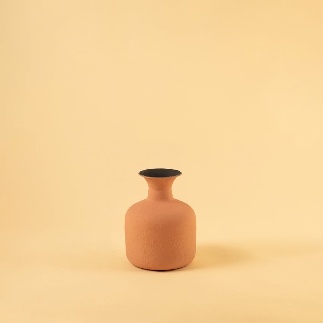Terracotta matte textured vase showcased on a clean white background highlighting its curved shape and subtle earthy tone with dried stems gently arranged.