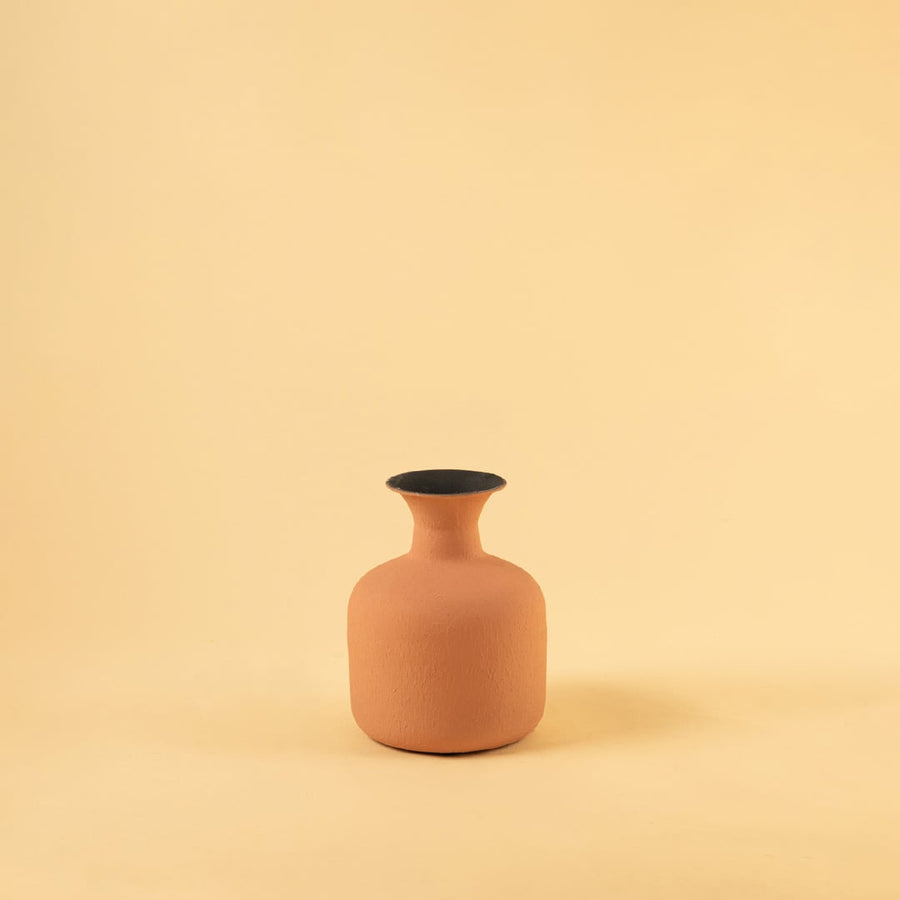 Terracotta matte textured vase showcased on a clean white background highlighting its curved shape and subtle earthy tone with dried stems gently arranged.
