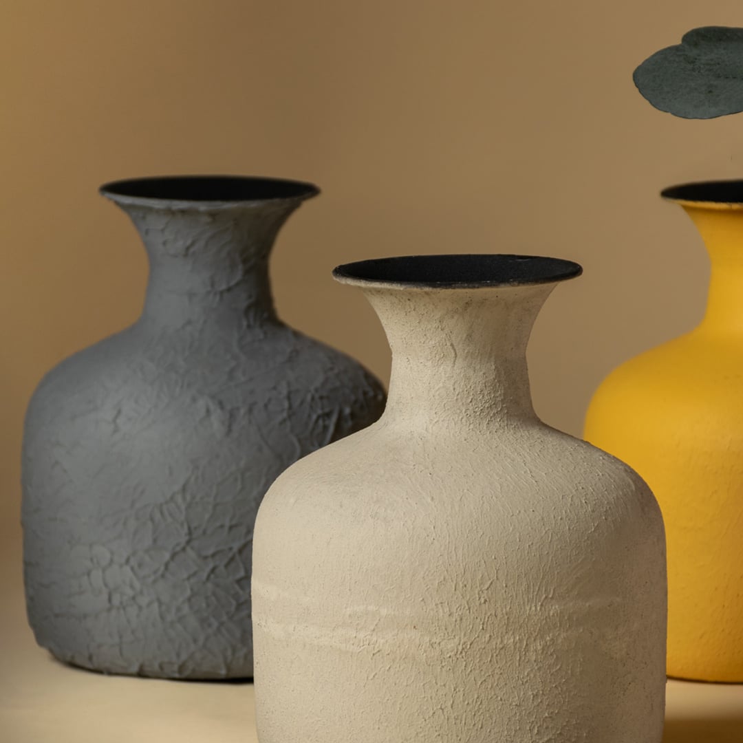 A closeup view of a yellow matte vase with dried stems showcasing its textured surface and gently curved top opening perfect for highlighting its handcrafted look.
