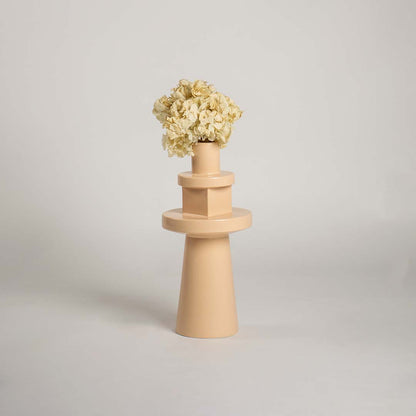 Front view of the nude colored stoneware flower pot with sculptural totem shape isolated on a plain white studio background setting.