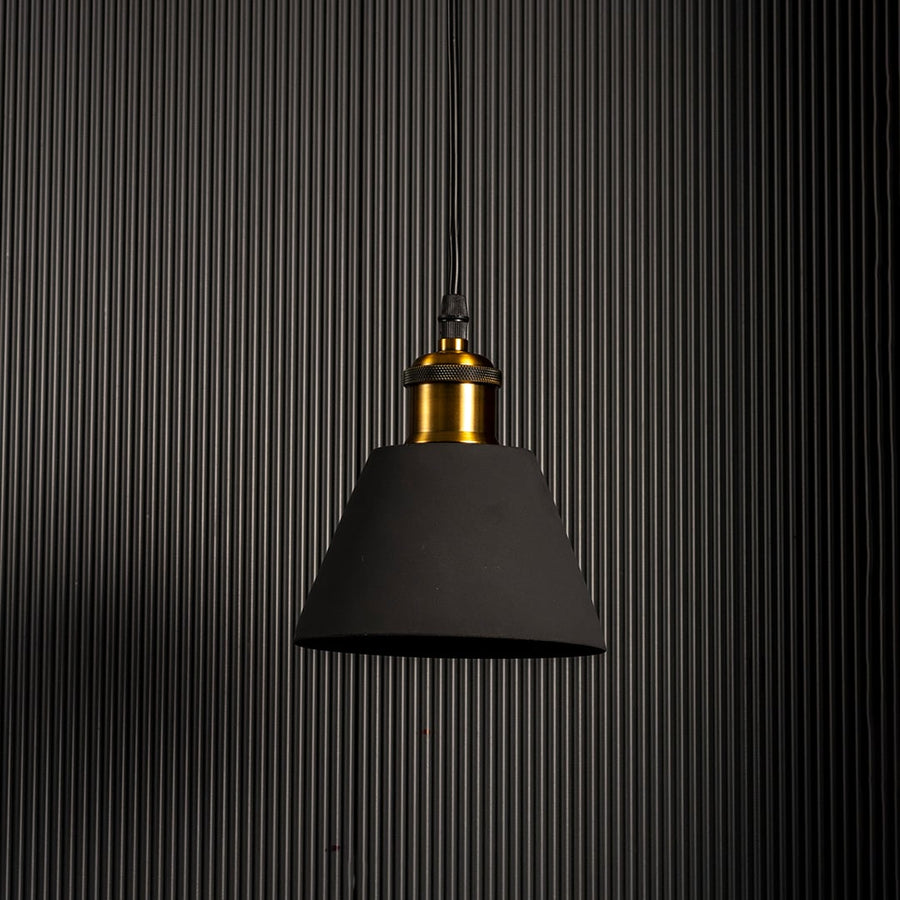 Minimal pendant light with matte black metal shade and brass holder styled for modern kitchen dining and studio interiors.