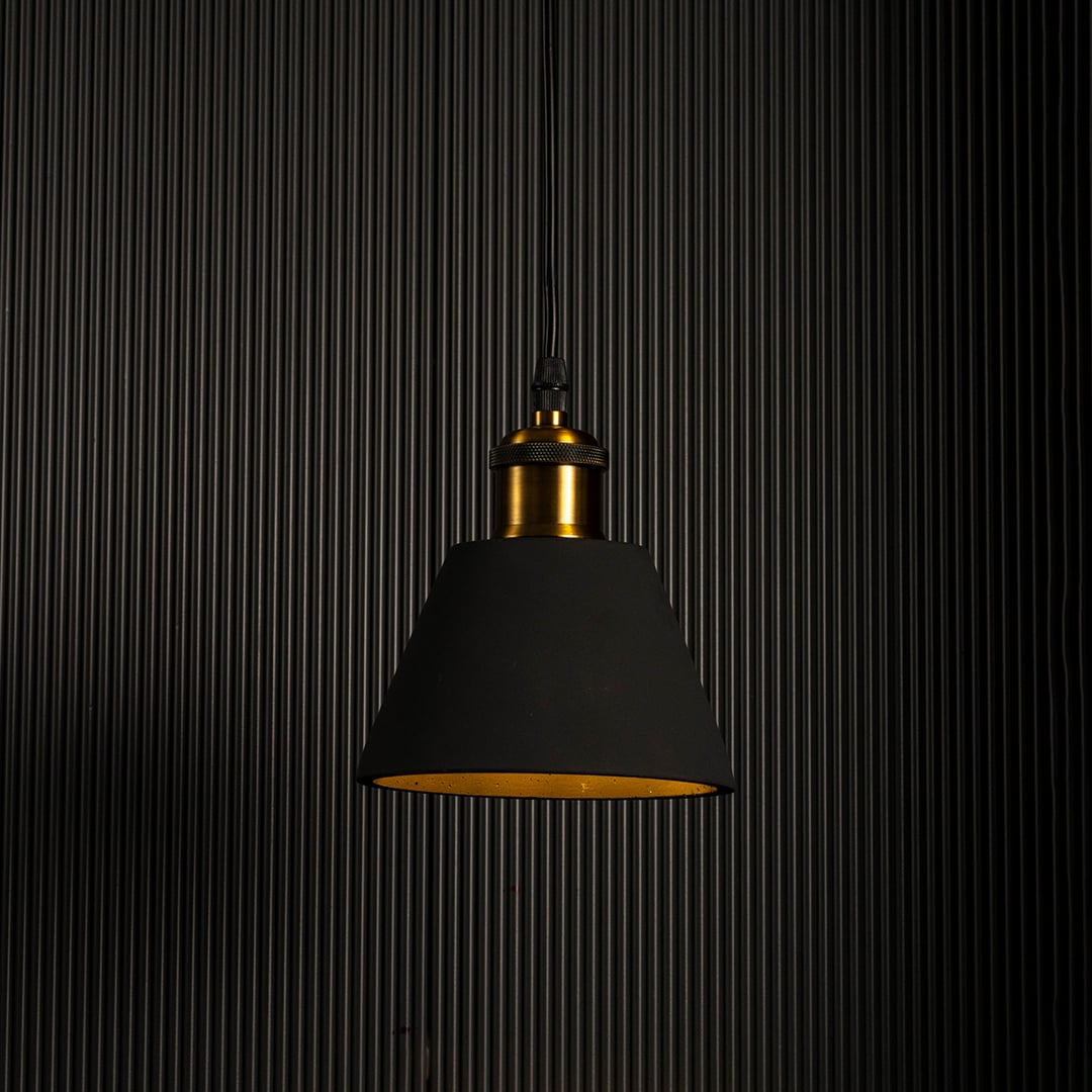 Black cone pendant lamp glowing brightly against a dark background highlighting its elegant modern shape.
