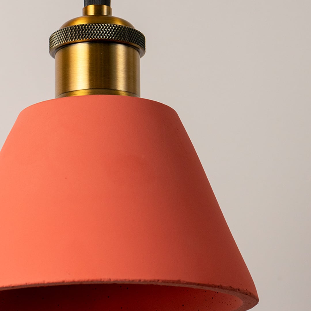Terracotta cone pendant light featuring a sleek conical shade and brass holder displayed with the light turned off.