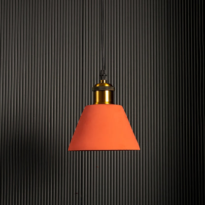 Terracotta cone pendant light glowing brightly against a dark background emphasizing its stylish silhouette.