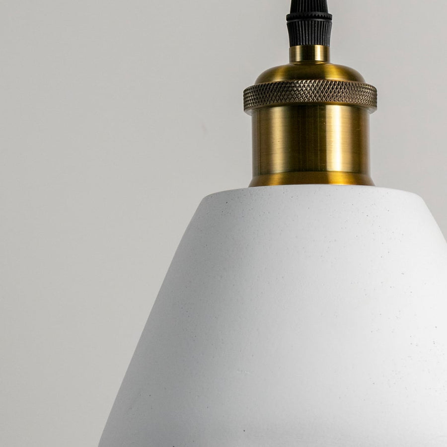 Closeup of cone pendant light turned off showing sleek brass fitting and smooth matte finish for elegant lighting design.