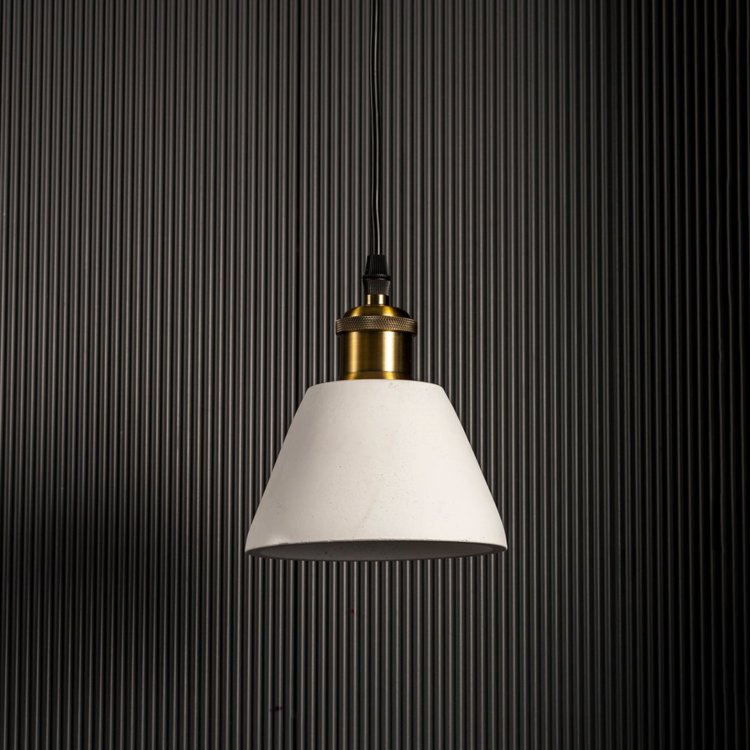 Black cone pendant light turned off highlighting matte texture and brass accent against black wall.