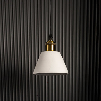 Black cone pendant light turned off highlighting matte texture and brass accent against black wall.