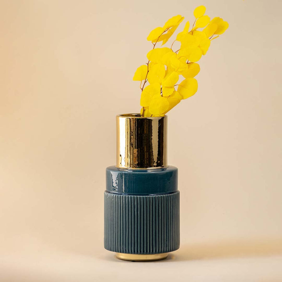 Blue and gold ceramic vase shown on a white background with no lighting effects highlighting its textured ribbed body and polished metallic top.