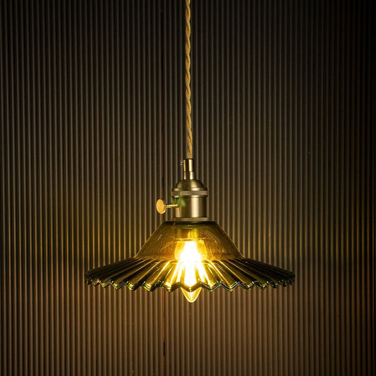 Brass metal pendant light with petal shade glowing beautifully for vintage decor.