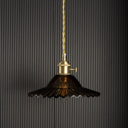 Luxury pendant light with gold metal shade glowing on black background creating dramatic ambience for modern home interiors.