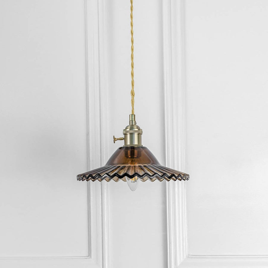 Bronze fluted metal pendant light with antique brass fittings crafted for elegant dining spaces.