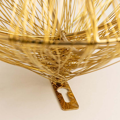 Closeup of golden wire wall decor showing intricate handcrafted circular detailing for modern decoration.