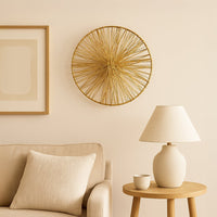 Golden wire wall decor piece styled above sofa with lamp and artwork enhancing modern living room decor.