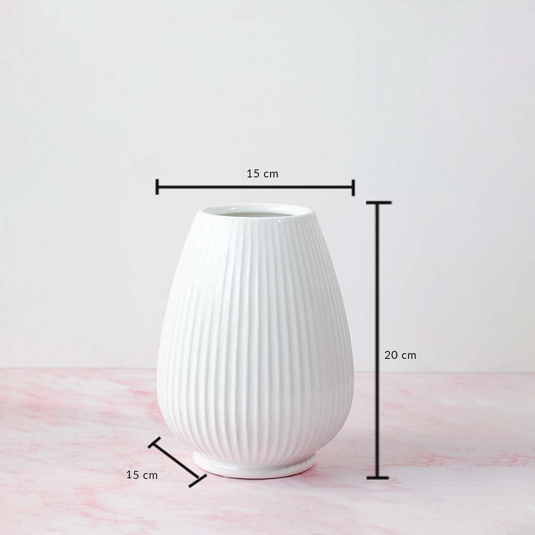 White ribbed vase with product dimensions labeled—20 cm height and 15 cm width—displayed on a pink marble background.