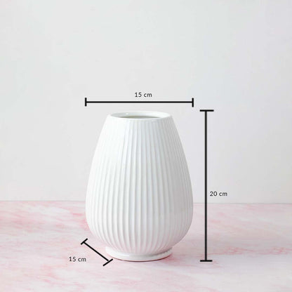 White ribbed vase with product dimensions labeled—20 cm height and 15 cm width—displayed on a pink marble background.