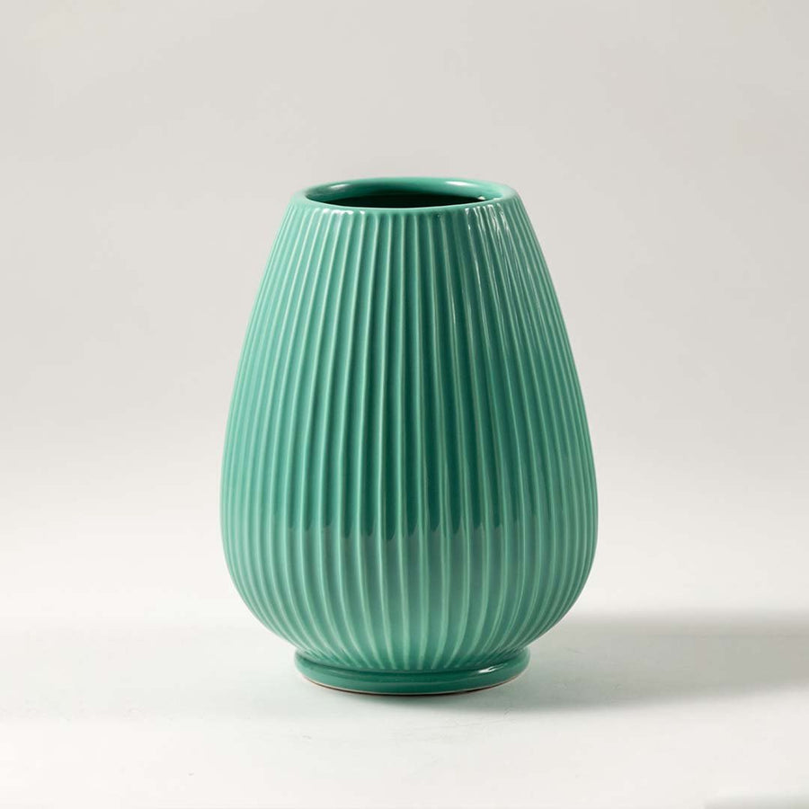 Green ceramic decorative vase with ribbed texture and rounded form for elegant tabletop styling and home decor.