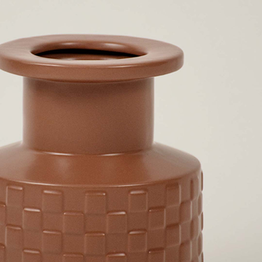 Closeup of terracotta ceramic vase showing basket weave texture and matte finish ideal for minimal home interiors.