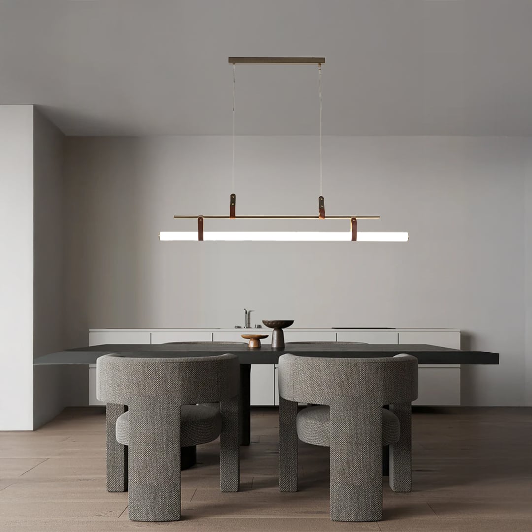Gold linear pendant light with white tube diffuser styled in a modern dining space adding bright elegant ambient lighting.