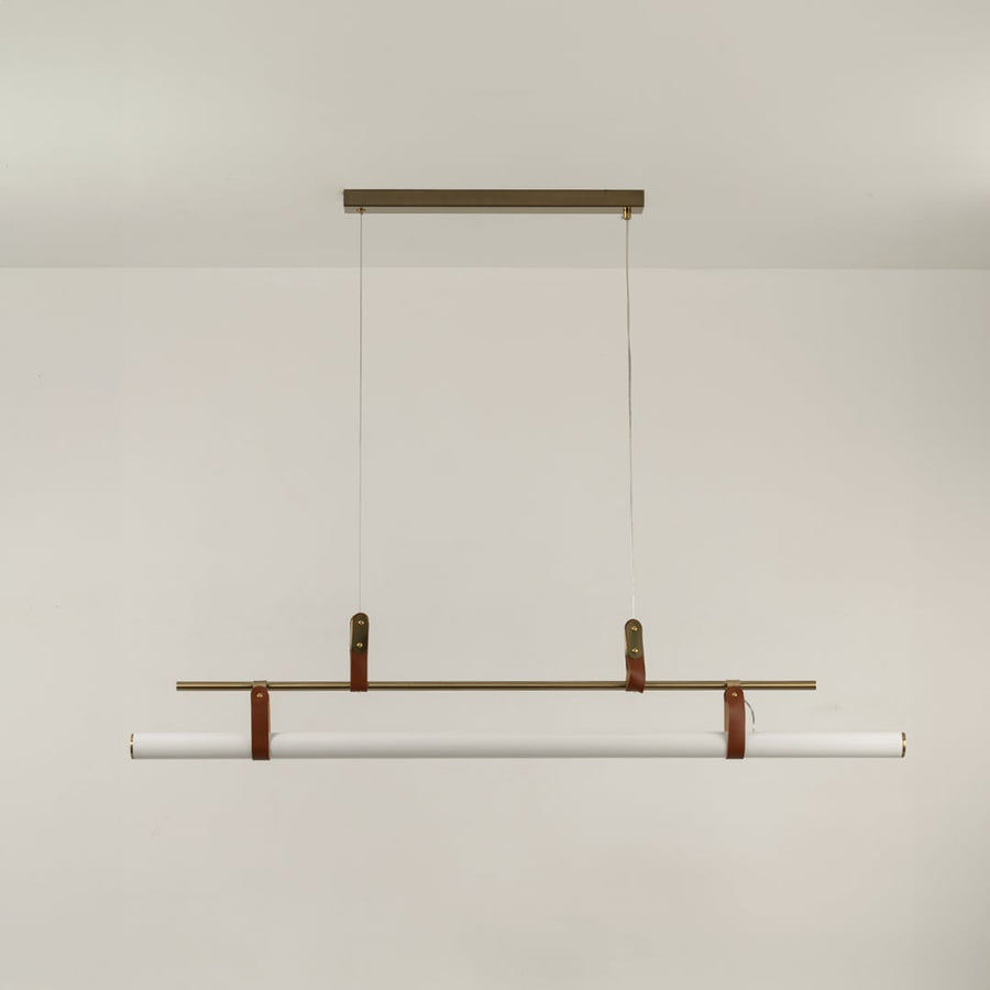 Gold linear pendant light on a white background with the light off highlighting its slim sculptural minimal design.