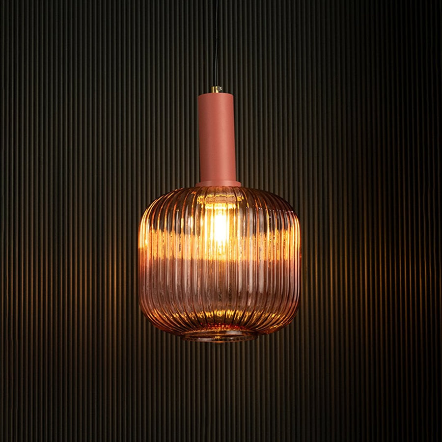 Modern pink glass pendant light glowing vividly on dark background.