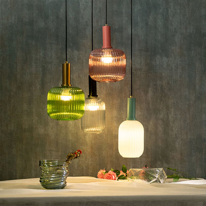 Modern ribbed glass pendant lights in green pink clear and white shades hanging together for elegant home lighting.