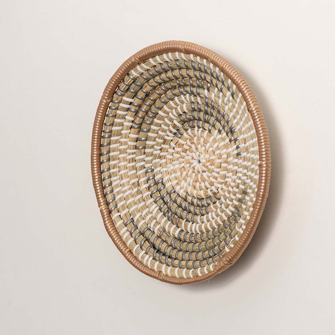 Side angle of woven wall basket highlighting its shallow bowl shape structured frame and natural material depth suitable for rustic or farmhouse interiors.