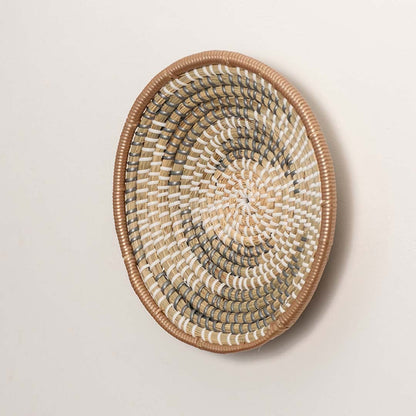 Side angle of woven wall basket highlighting its shallow bowl shape structured frame and natural material depth suitable for rustic or farmhouse interiors.