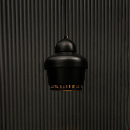 Black industrial pendant light with ribbed detailing against dark panel wall with light on for contemporary décor.