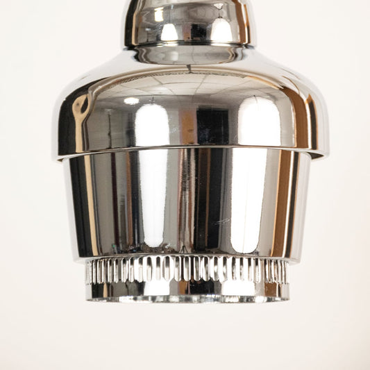Chrome industrial pendant light shown in close up view with ribbed detailing against plain background for sleek modern décor.