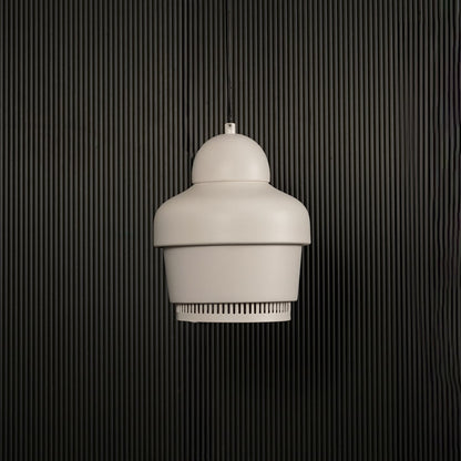 White industrial pendant light with ribbed detailing hanging against dark textured wall with light off for clean modern décor.