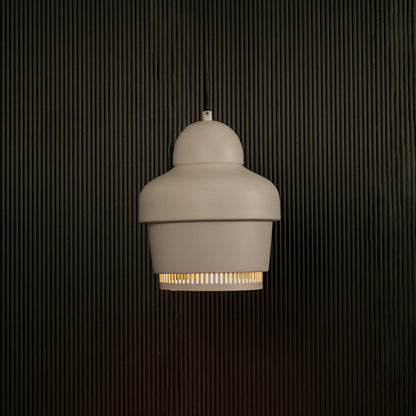 White industrial pendant light with ribbed detailing against dark textured wall with light on for clean minimal décor.