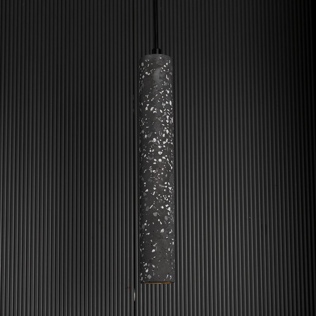 Amber glass pendant light glowing warmly against a dark background highlighting its translucent amber hue.
