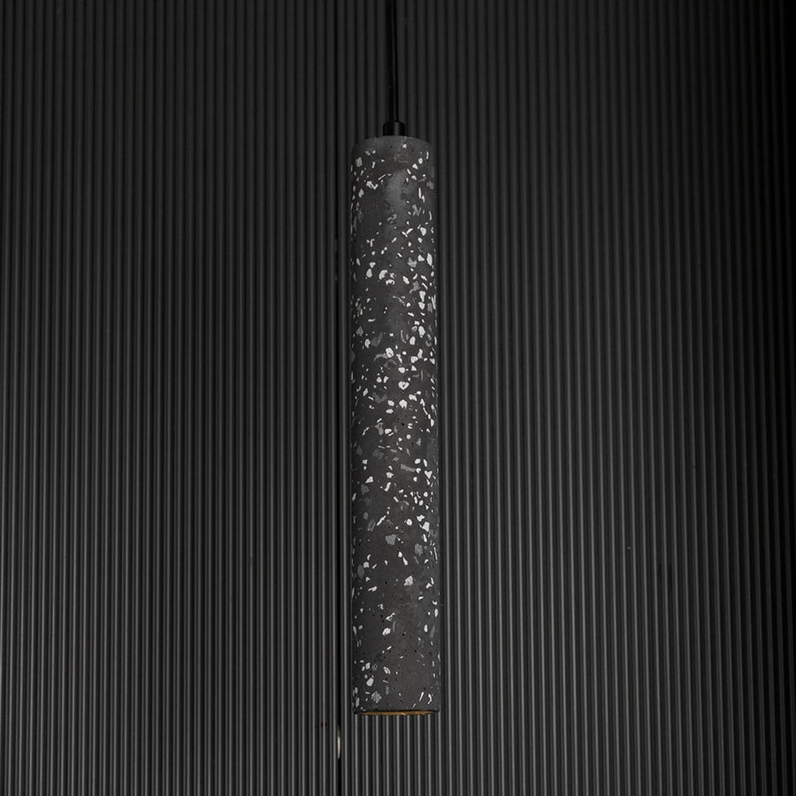 Amber glass pendant light glowing warmly against a dark background highlighting its translucent amber hue.