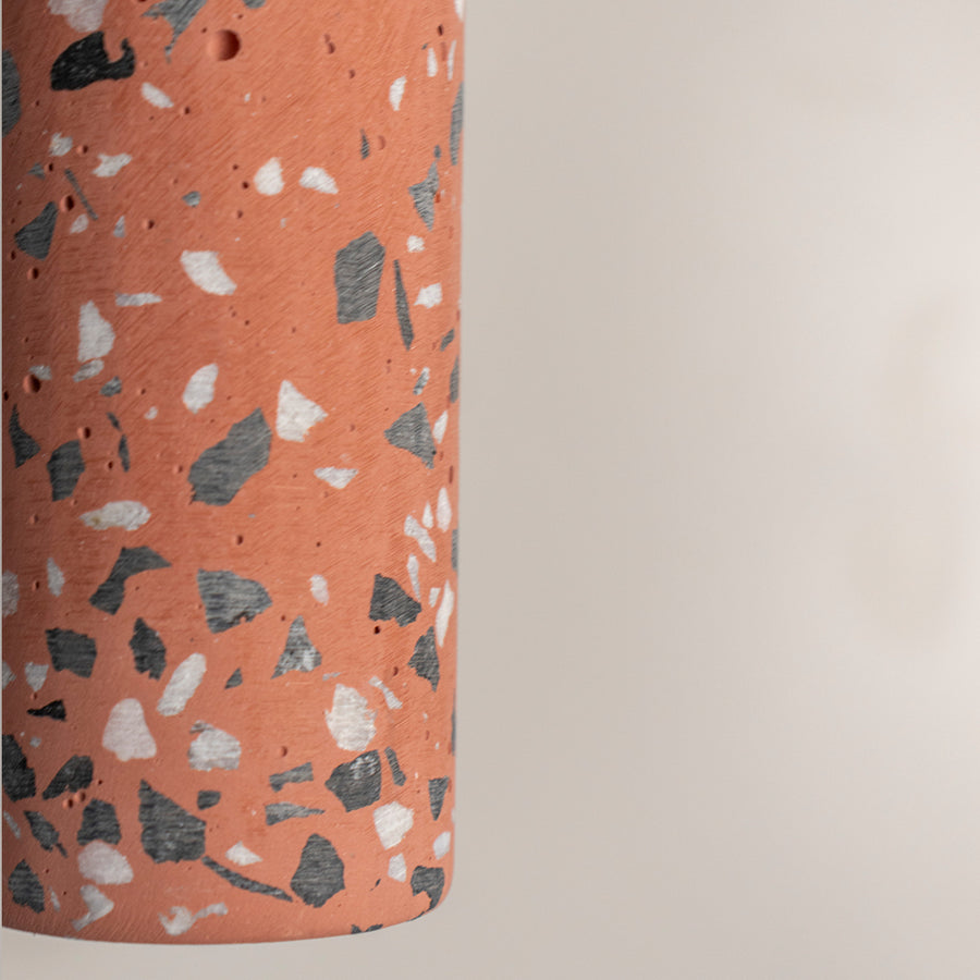 Closeup of terracotta terrazzo pendant light highlighting premium stone texture and artisan detailing.