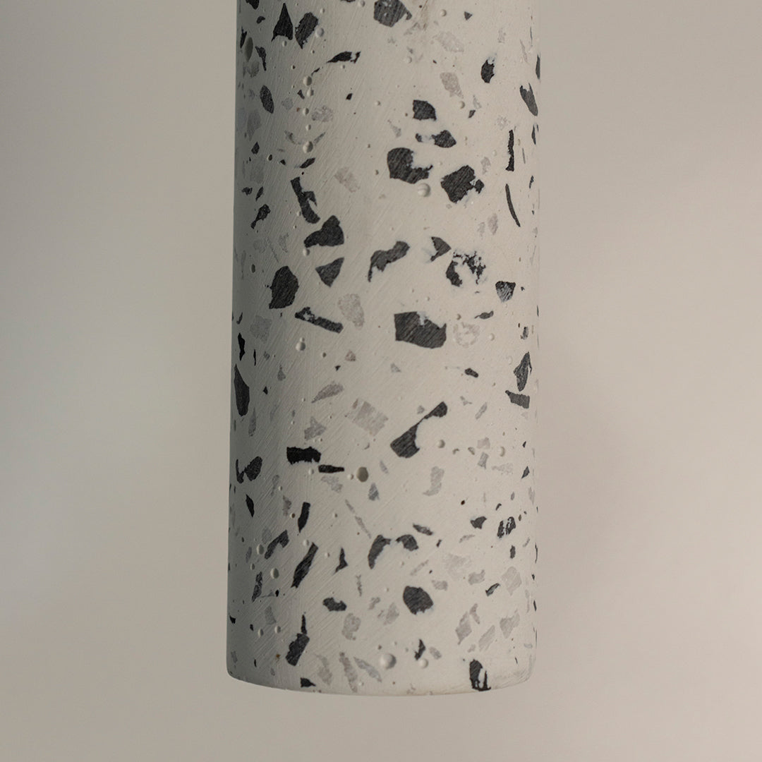 Closeup of white terrazzo pendant light with black speckled pattern showcasing premium craftsmanship.