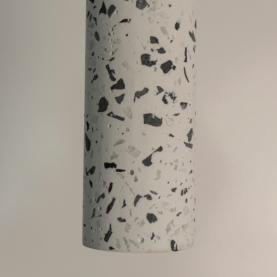 Closeup of white terrazzo pendant light with black speckled pattern showcasing premium craftsmanship.