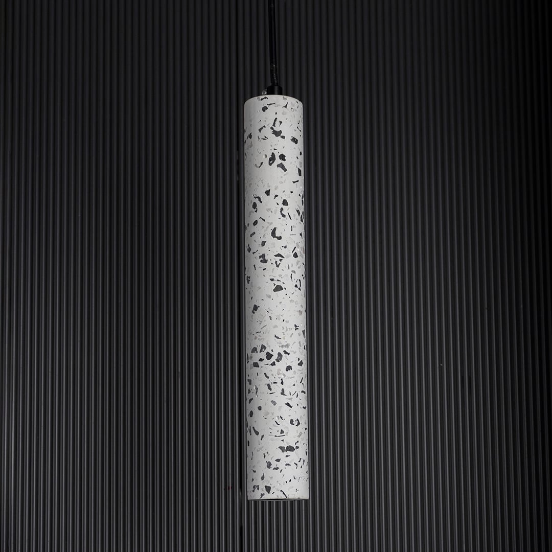 Terrazzo pendant light turned off softly on dark background highlighting fine terrazzo craftsmanship.