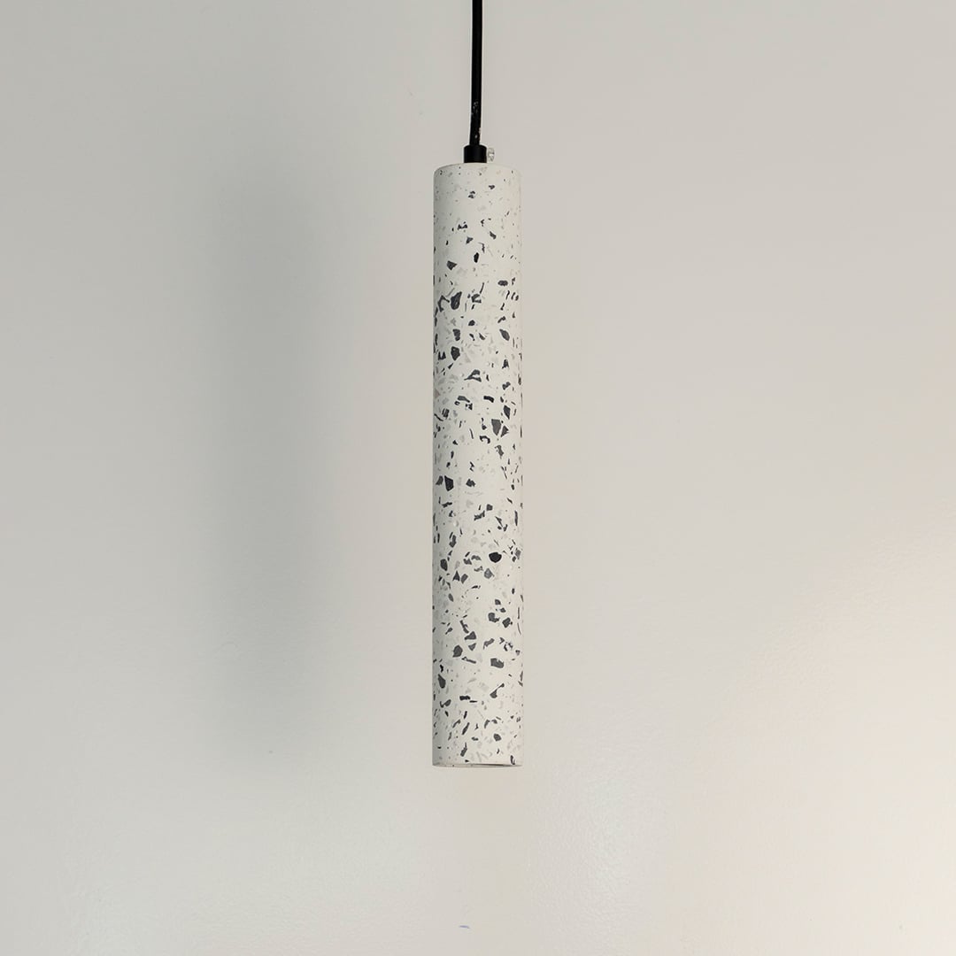 Cylindrical terrazzo pendant light with white stone texture and black accents for stylish interiors.