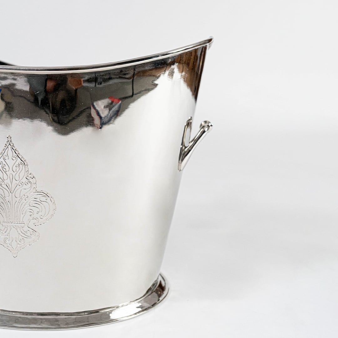 Ornate gold brass planter with floral engraving and dual handles placed on a plain white background.