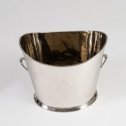 Polished brass floral planter with dual curved handles centered on white studio backdrop.